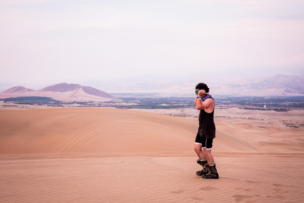 Un uomo in piedi sulla cima di una duna di sabbia