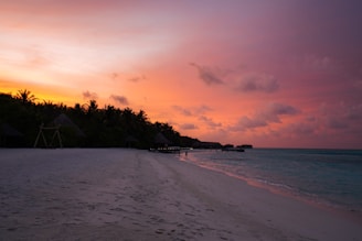 a beach with a sunset in the background