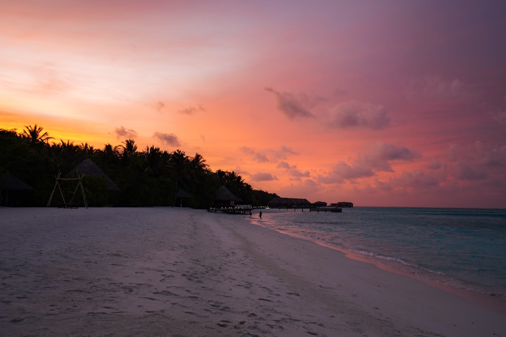 a beach with a sunset in the background