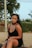 a woman sitting on the ground wearing a black dress