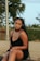 a woman sitting on the ground wearing a black dress
