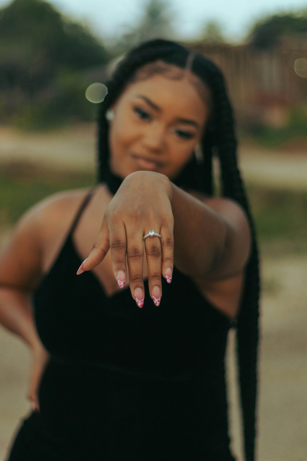 a woman in a black dress pointing at the camera