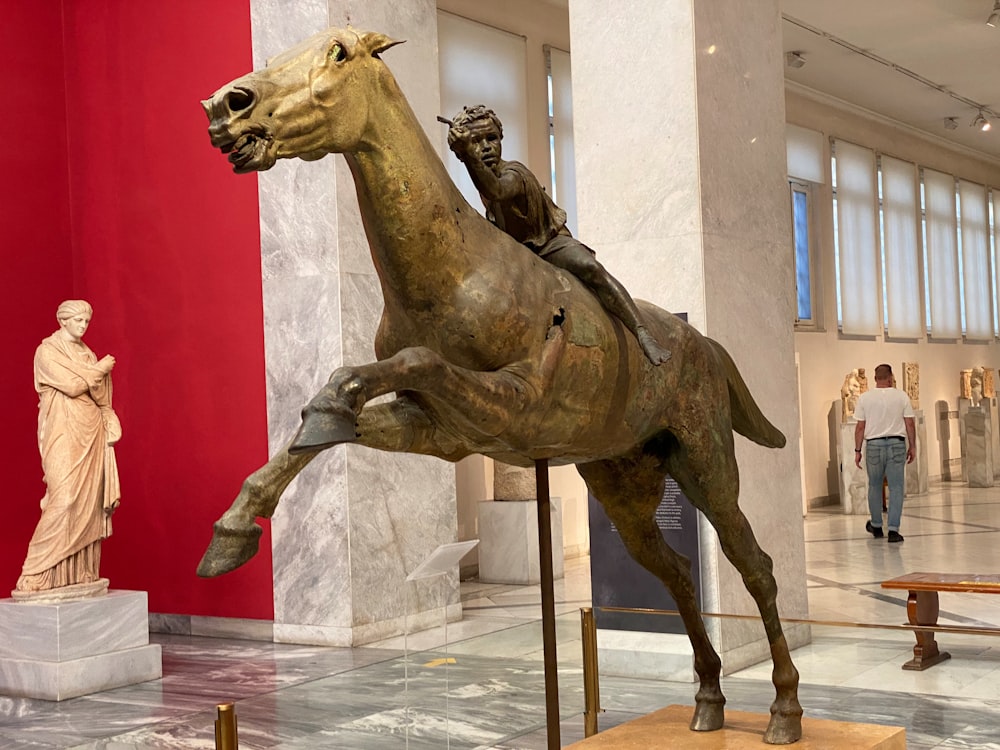 a statue of a man riding a horse in a museum