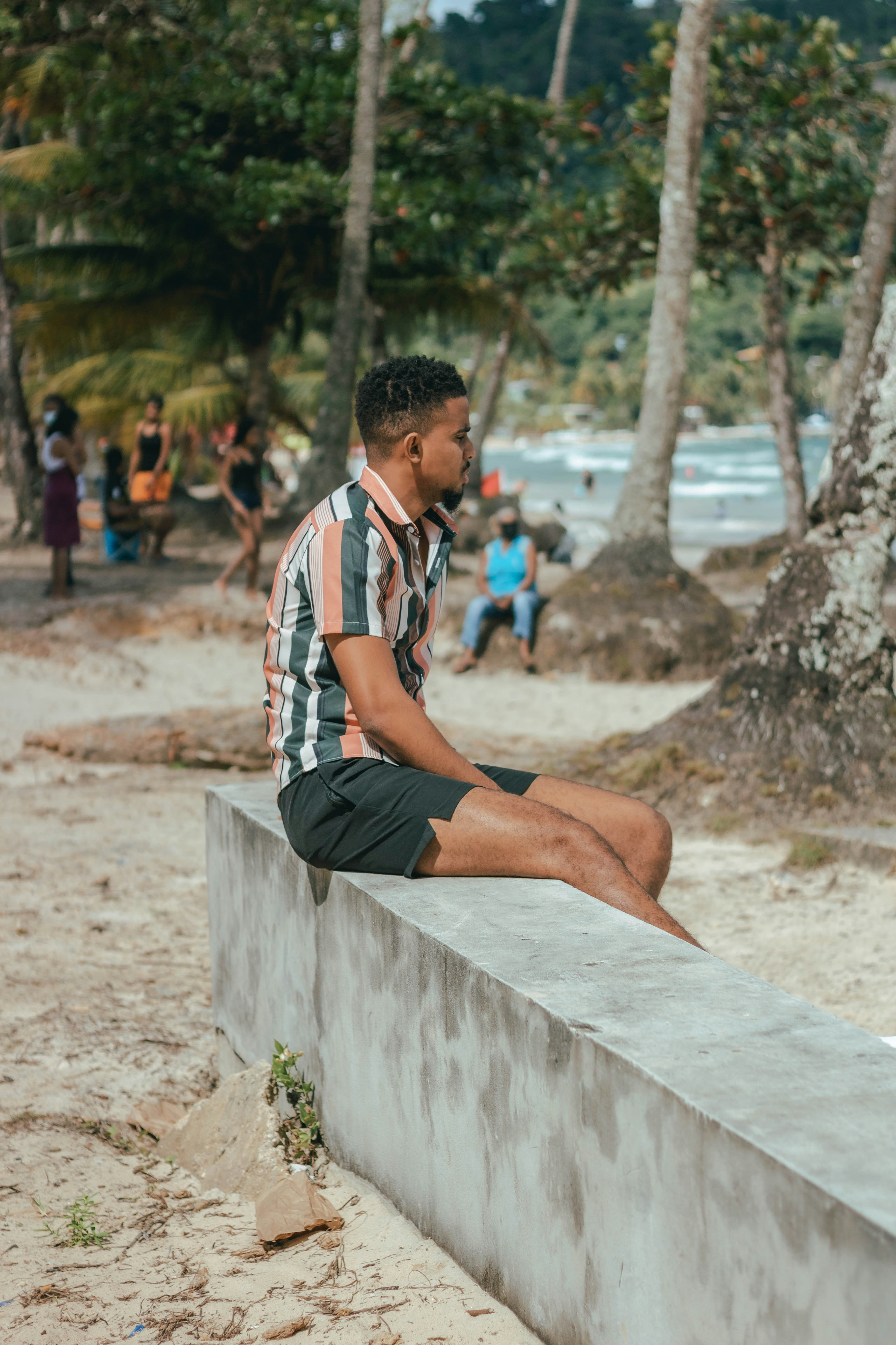 a man sitting on a concrete bench on the beach