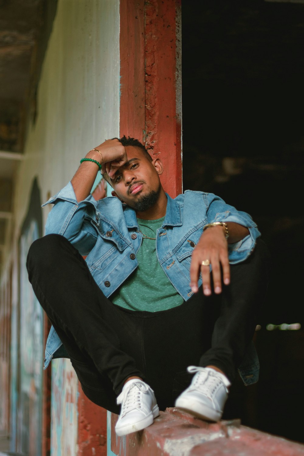 a man sitting on a wall with his hand on his head