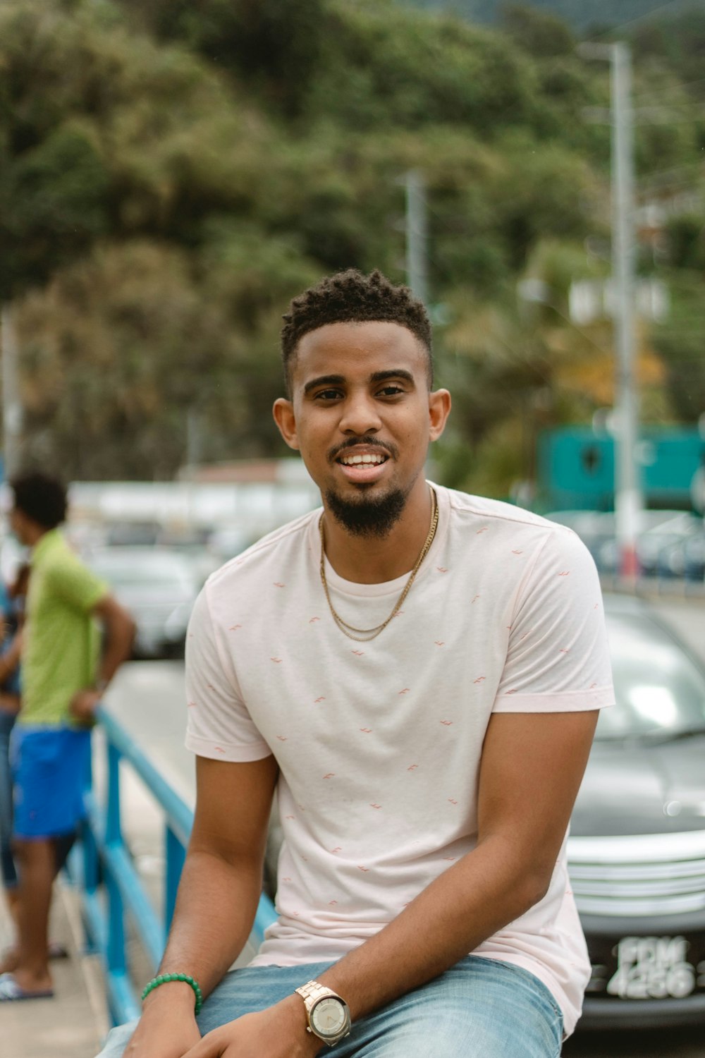 a man sitting on a rail in a parking lot