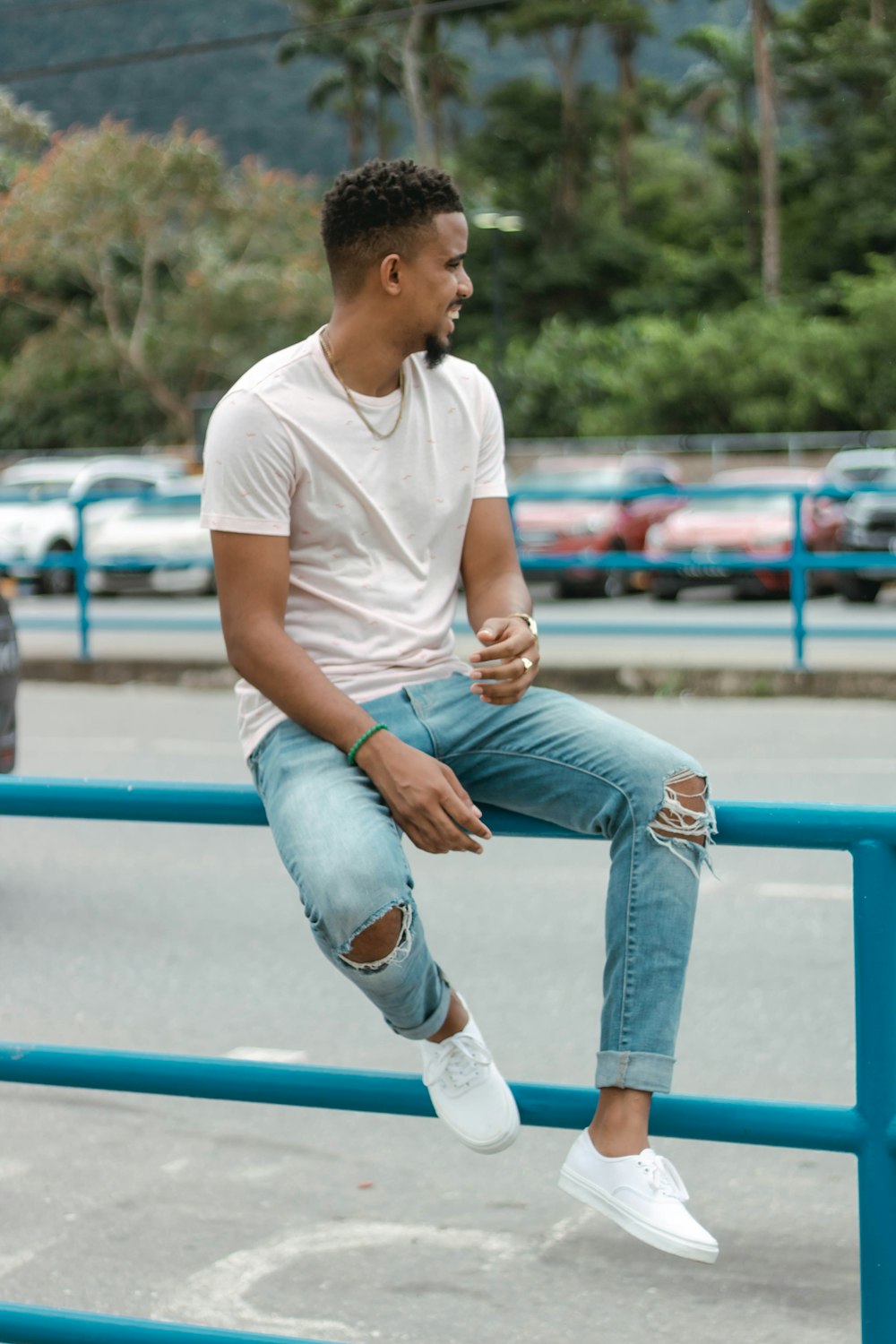 a man sitting on a rail in a parking lot