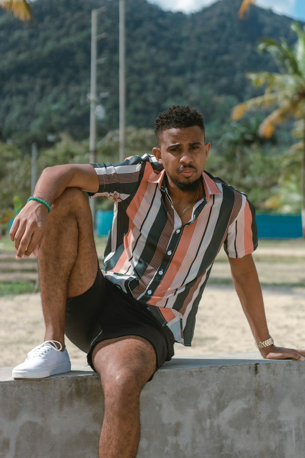 a man sitting on a cement wall with his legs crossed