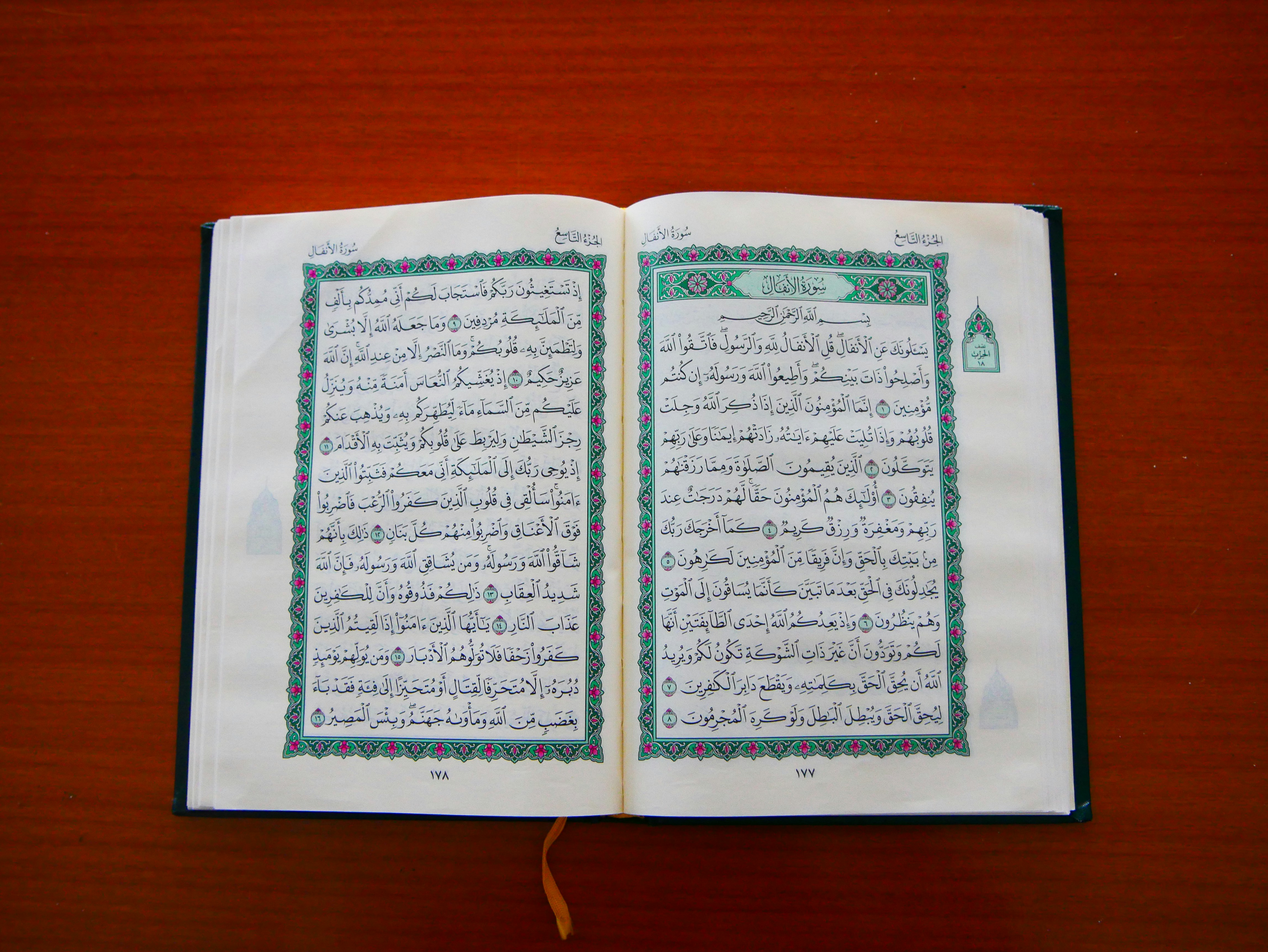 an open book with arabic writing on a wooden table