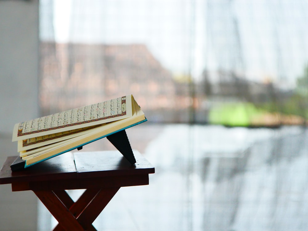 um livro aberto sentado em cima de uma mesa de madeira