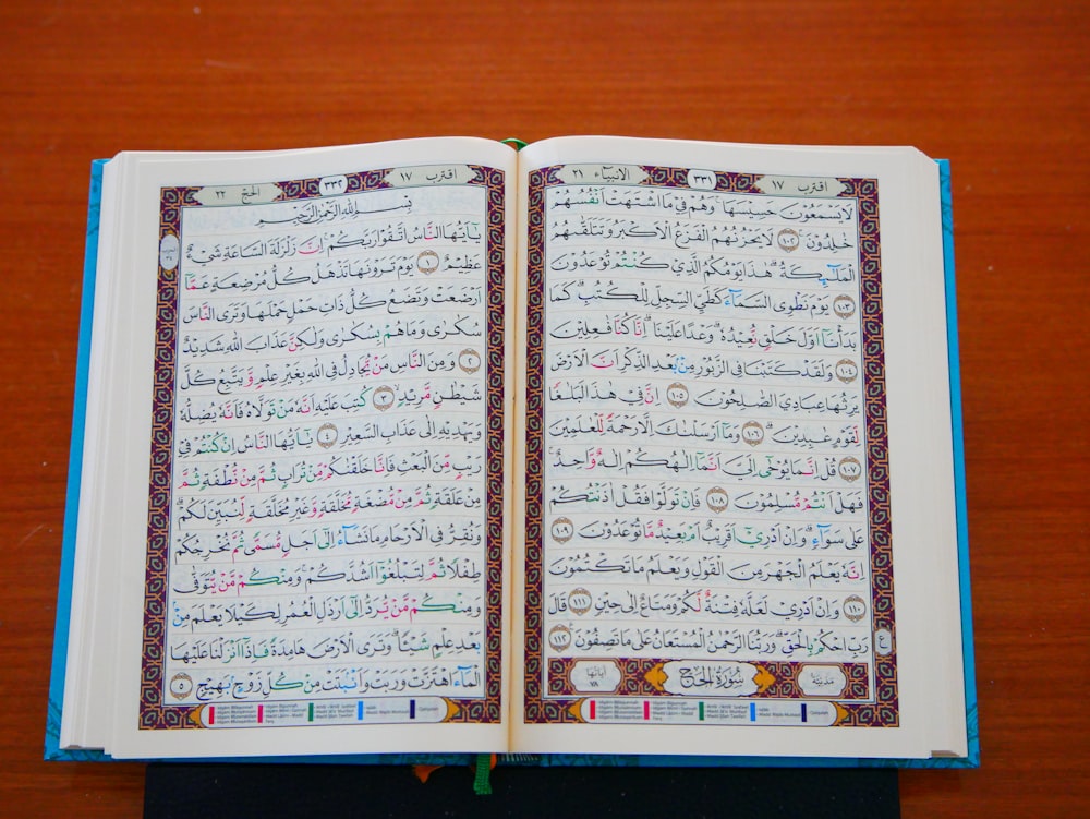 an open book with arabic writing on a wooden table