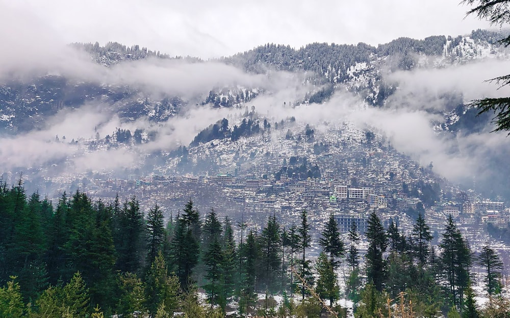 a view of a city in the mountains covered in clouds