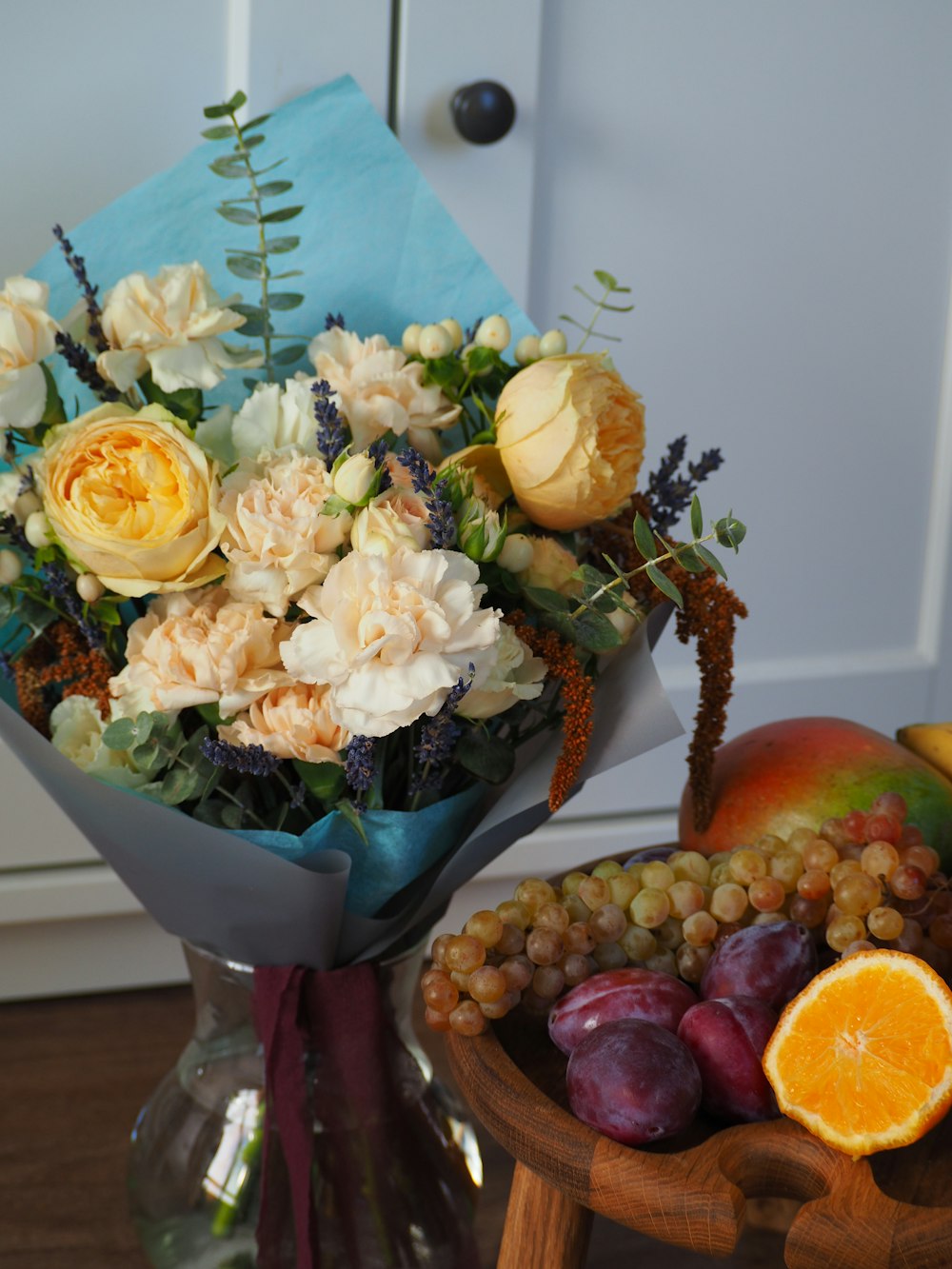 a bouquet of flowers and fruit on a table