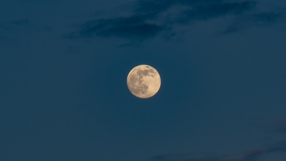 a full moon is seen in the night sky