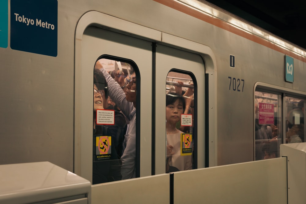 a subway train with people looking out the doors