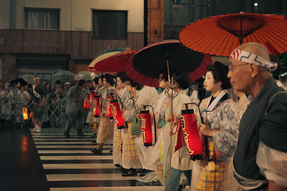 a group of people walking down a street holding umbrellas