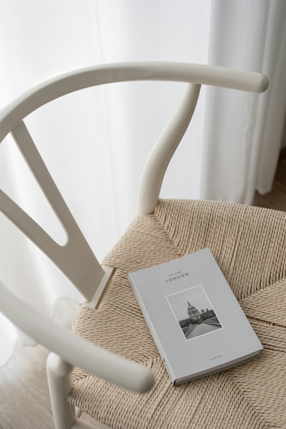 a book sitting on top of a chair next to a window