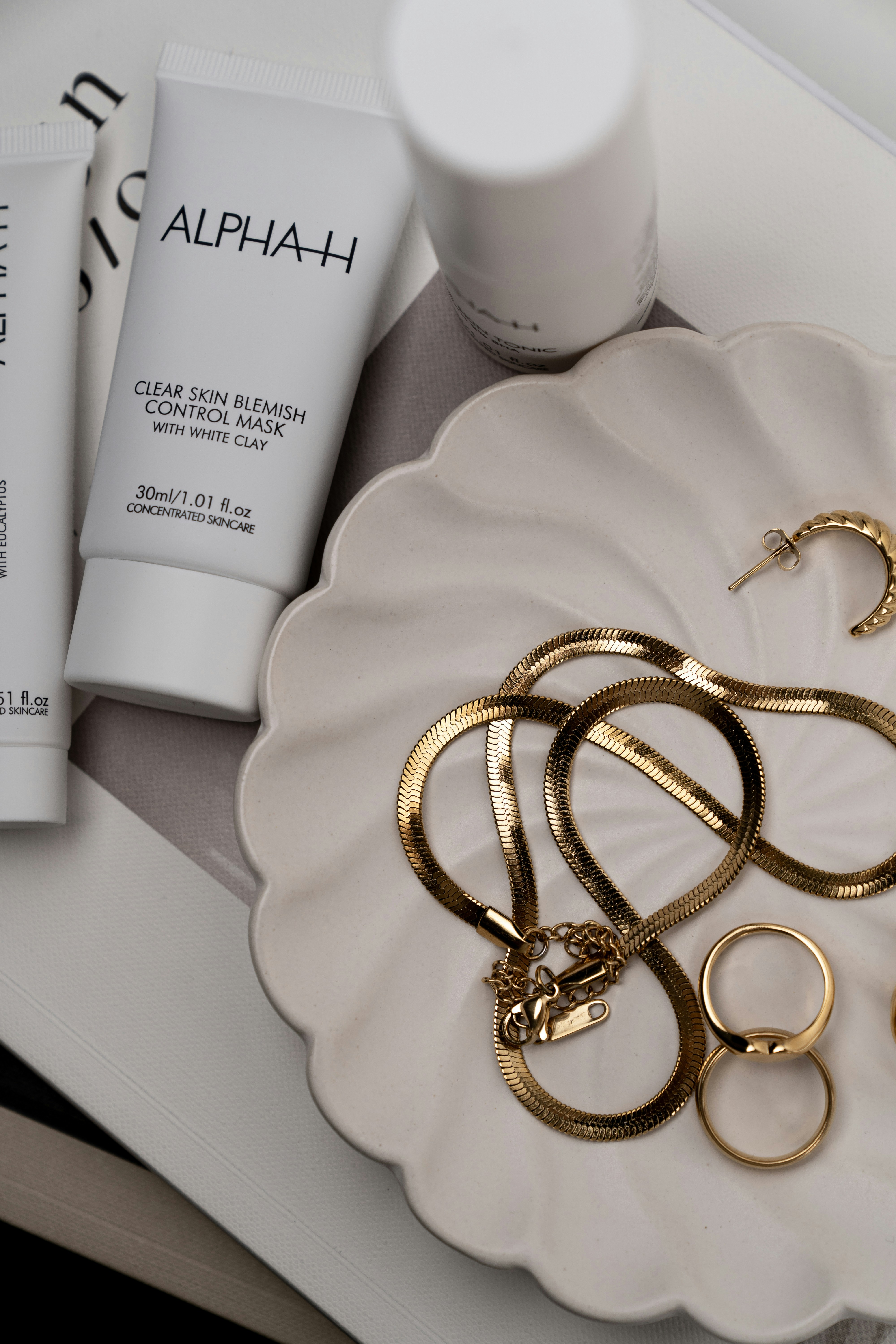 Luxury shopping bags and personal items on clean white surface, champagne gold accents, premium lifestyle
