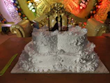 An elegant wedding cake adorned with hand-painted floral designs inspired by traditional Mexican crafts.