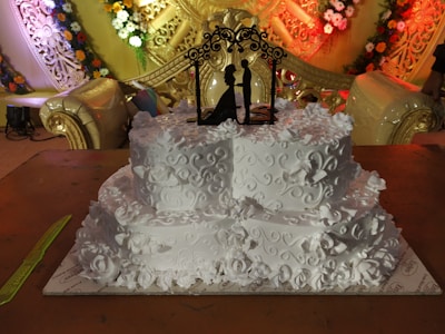 A beautifully crafted royal blue and gold-themed wedding cake with intricate detailing.