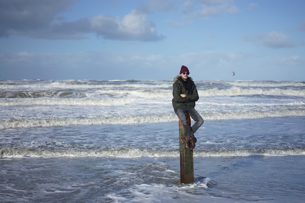 a person standing on a post in the water