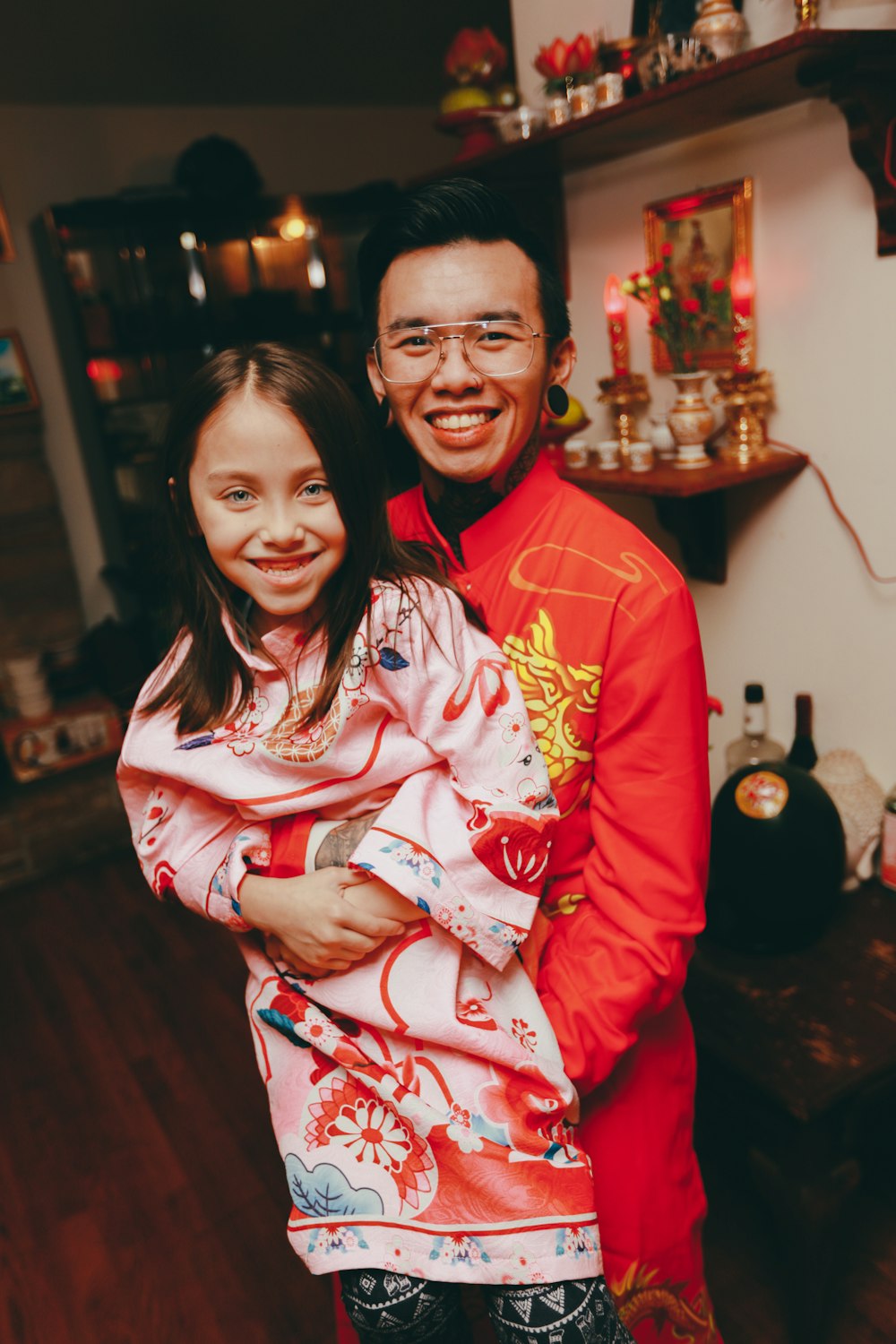 a man holding a girl in a room