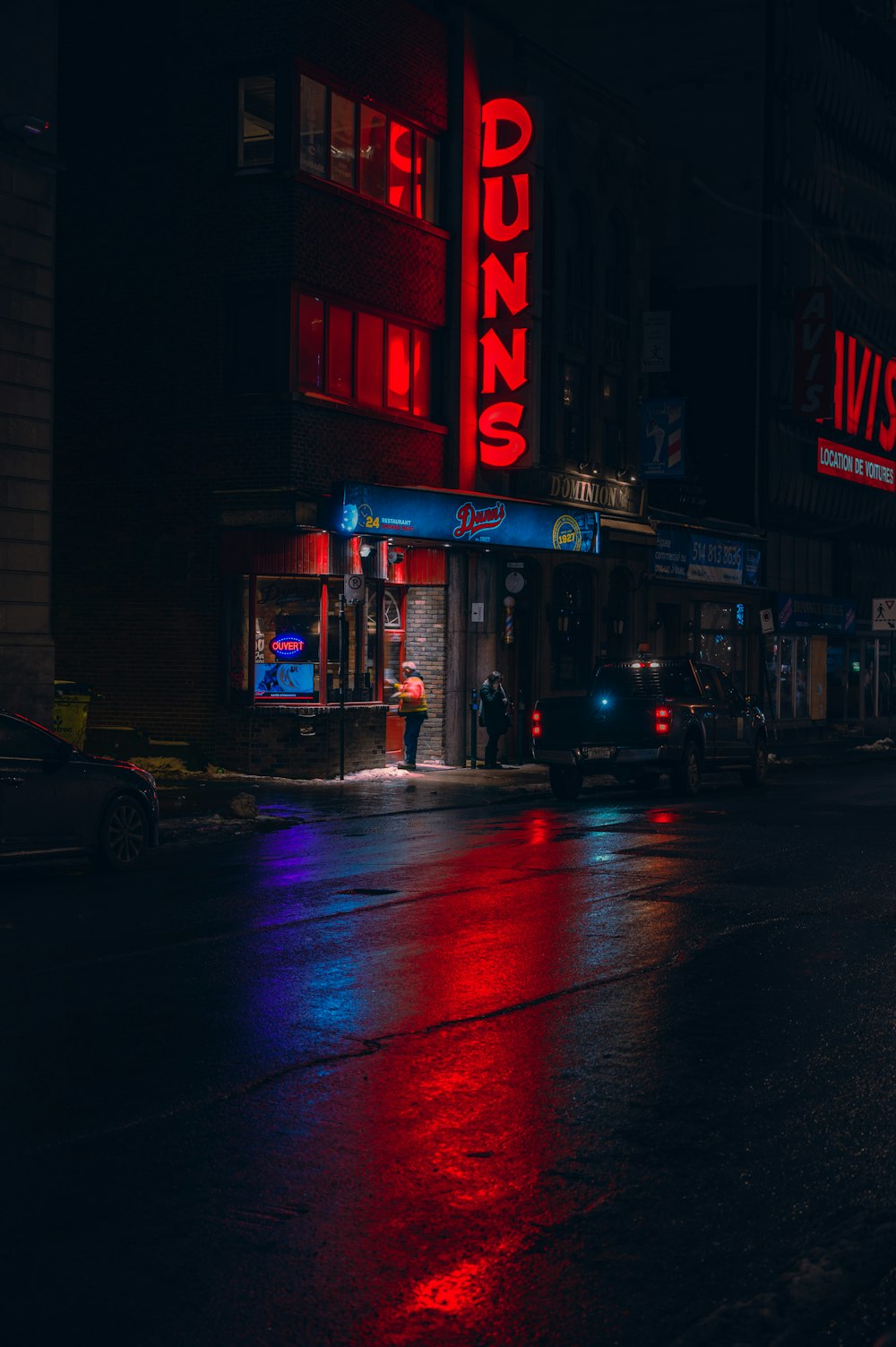 a city street at night with a neon sign