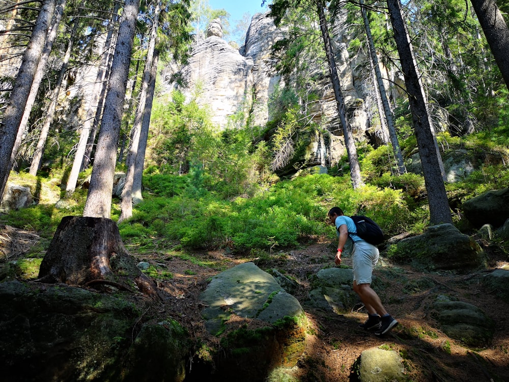 a man with a backpack walking through a forest