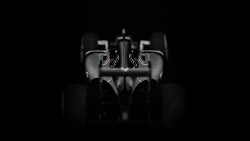 Futuristic dark-themed website homepage with sleek 3D elements and a Formula 1 car racing in background.