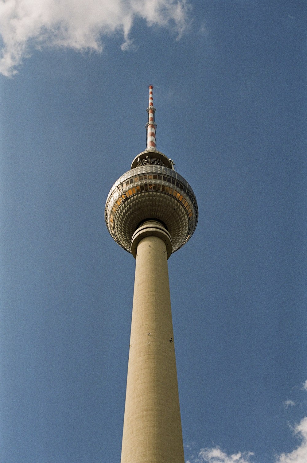 a large tall tower with a sky background with Fernsehturm Berlin in the background