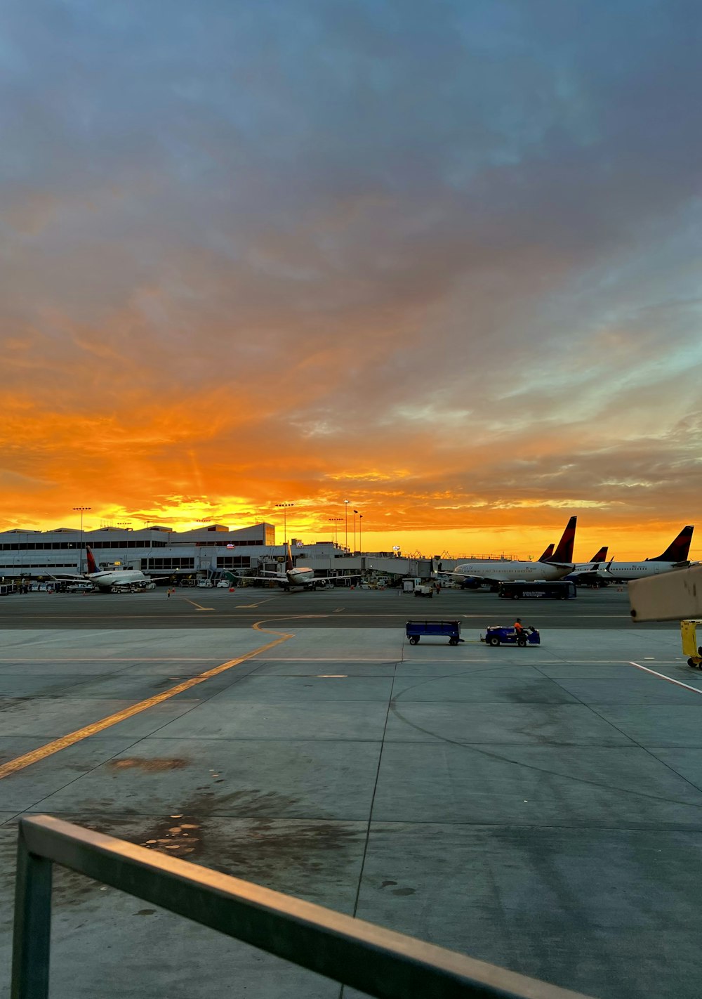 a view of an airport at sunset with planes on the tarmac