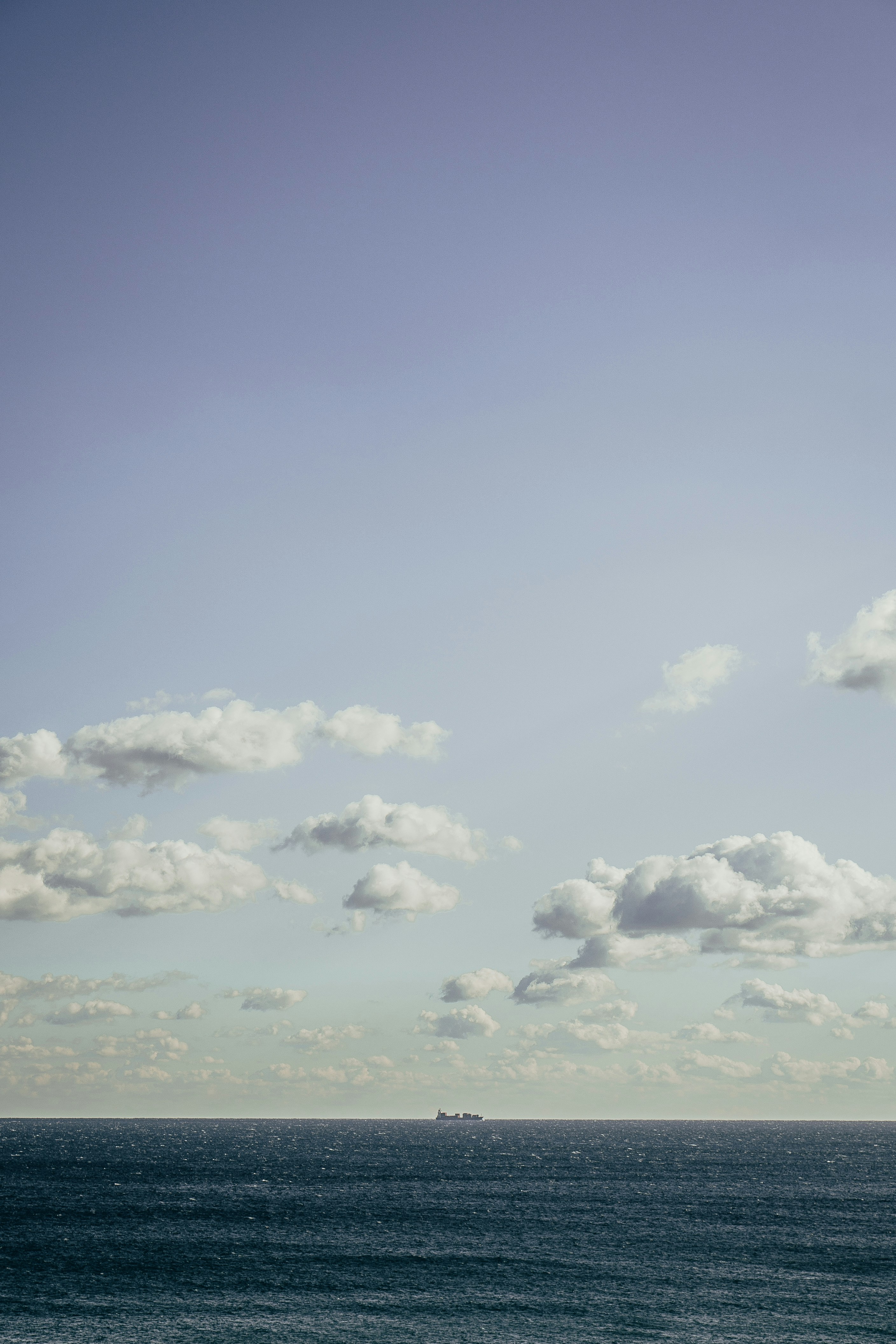 a large body of water sitting under a cloudy blue sky