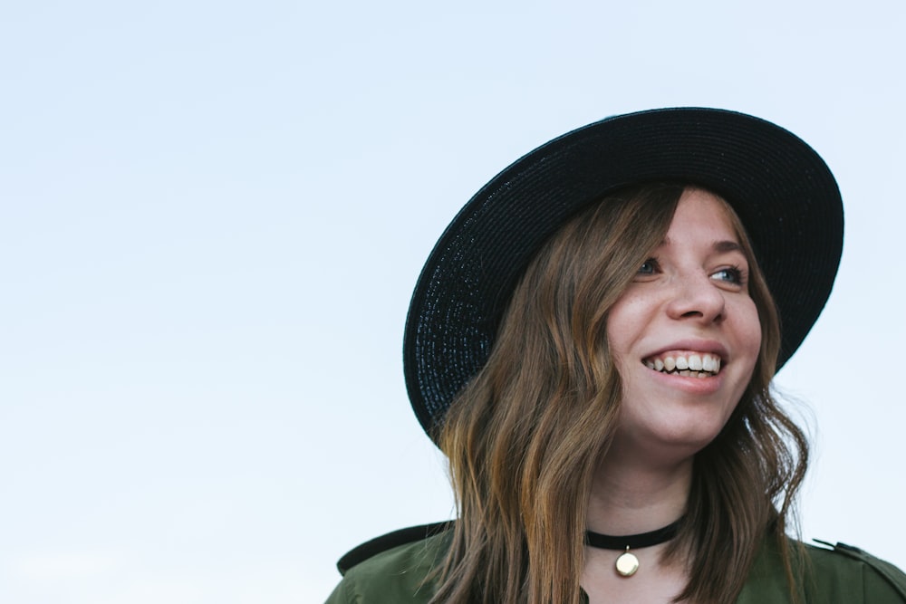 a woman wearing a black hat and a green jacket