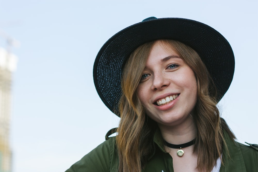 a woman wearing a black hat and green jacket