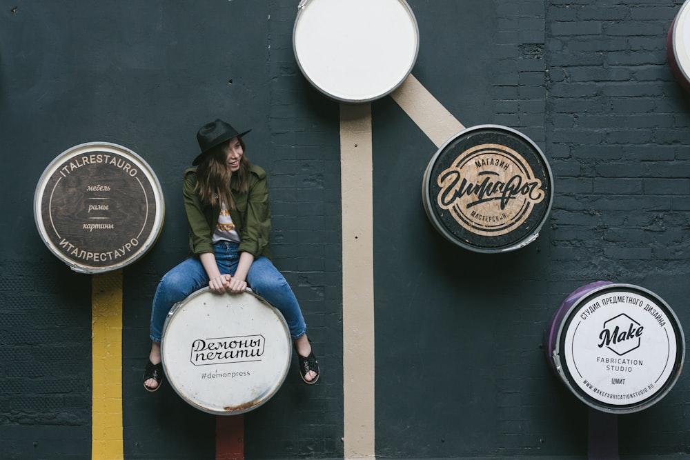 a woman sitting on top of a stool next to a wall