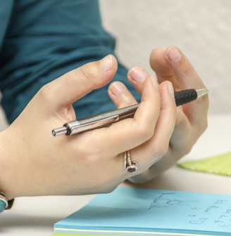 a person sitting at a table using a cell phone