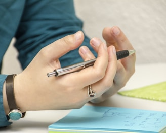 a person sitting at a table using a cell phone