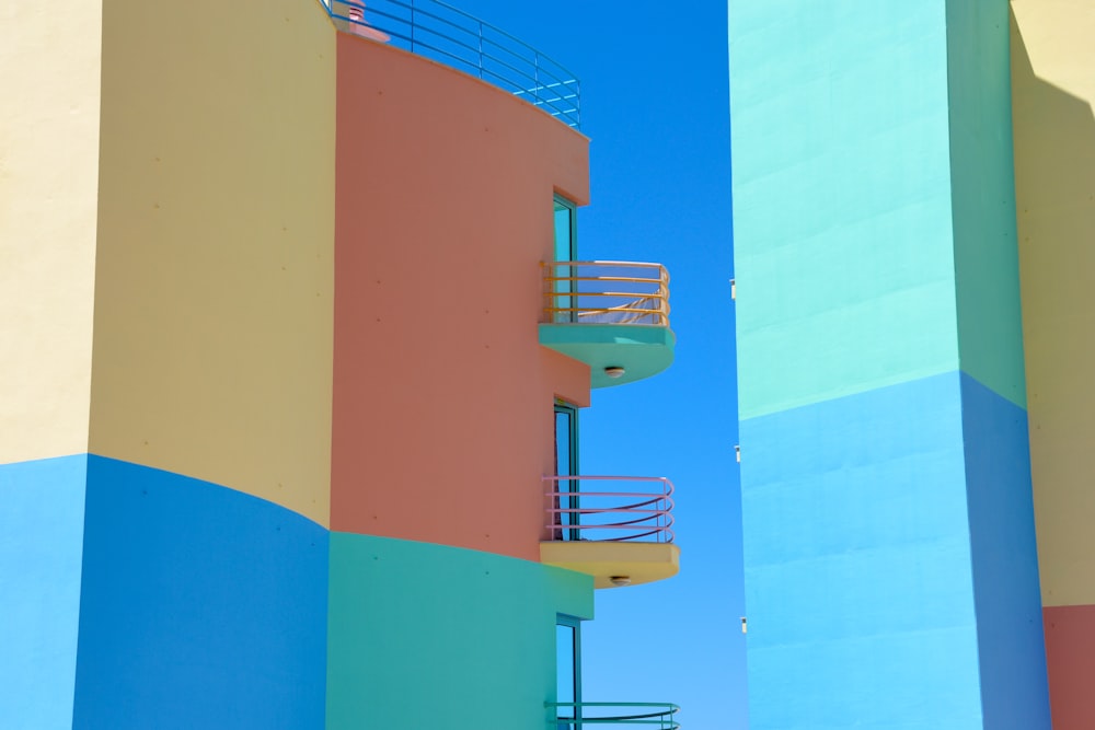 a tall multicolored building with a balcony