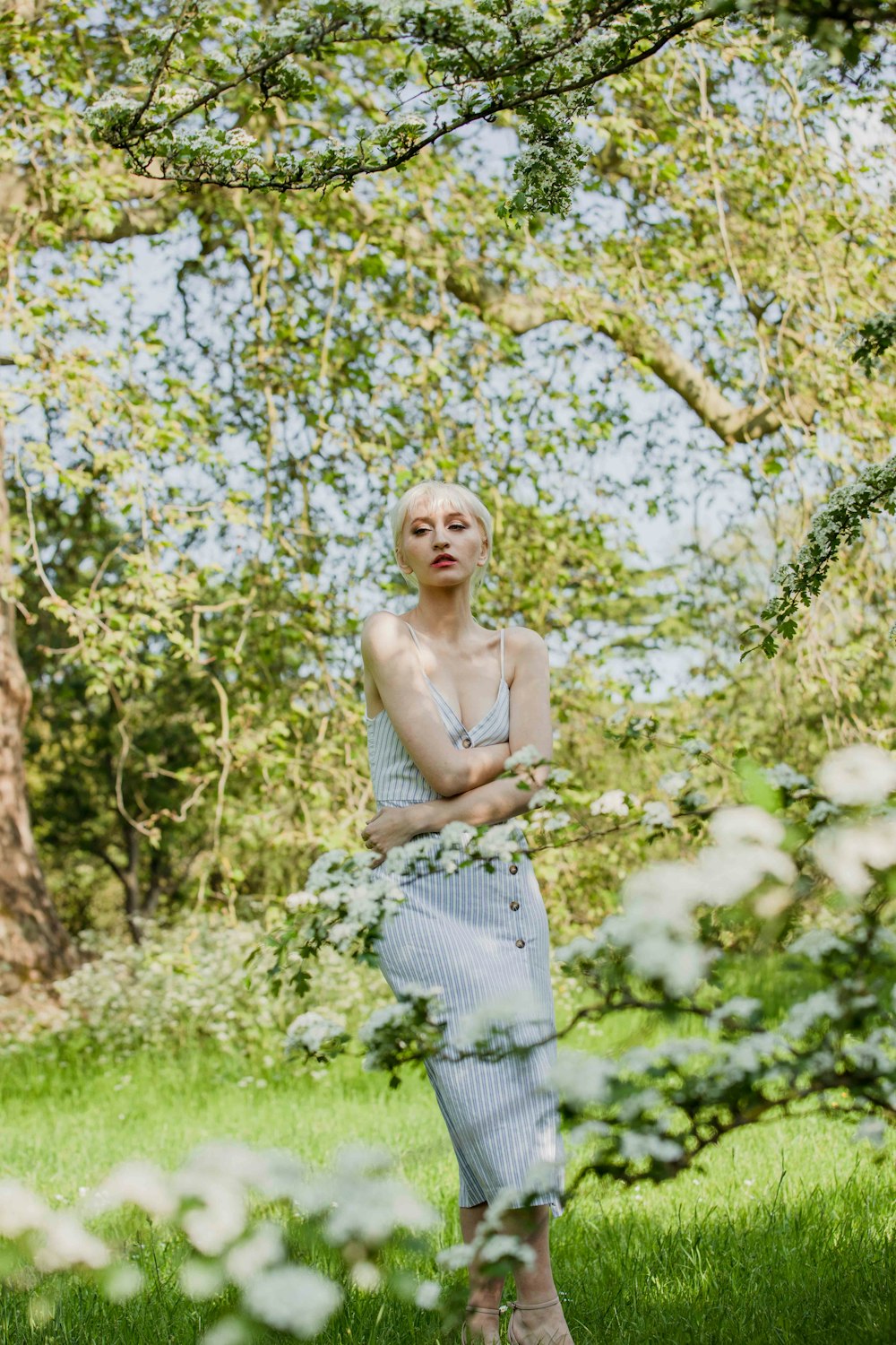 Une femme debout dans l’herbe, les bras croisés