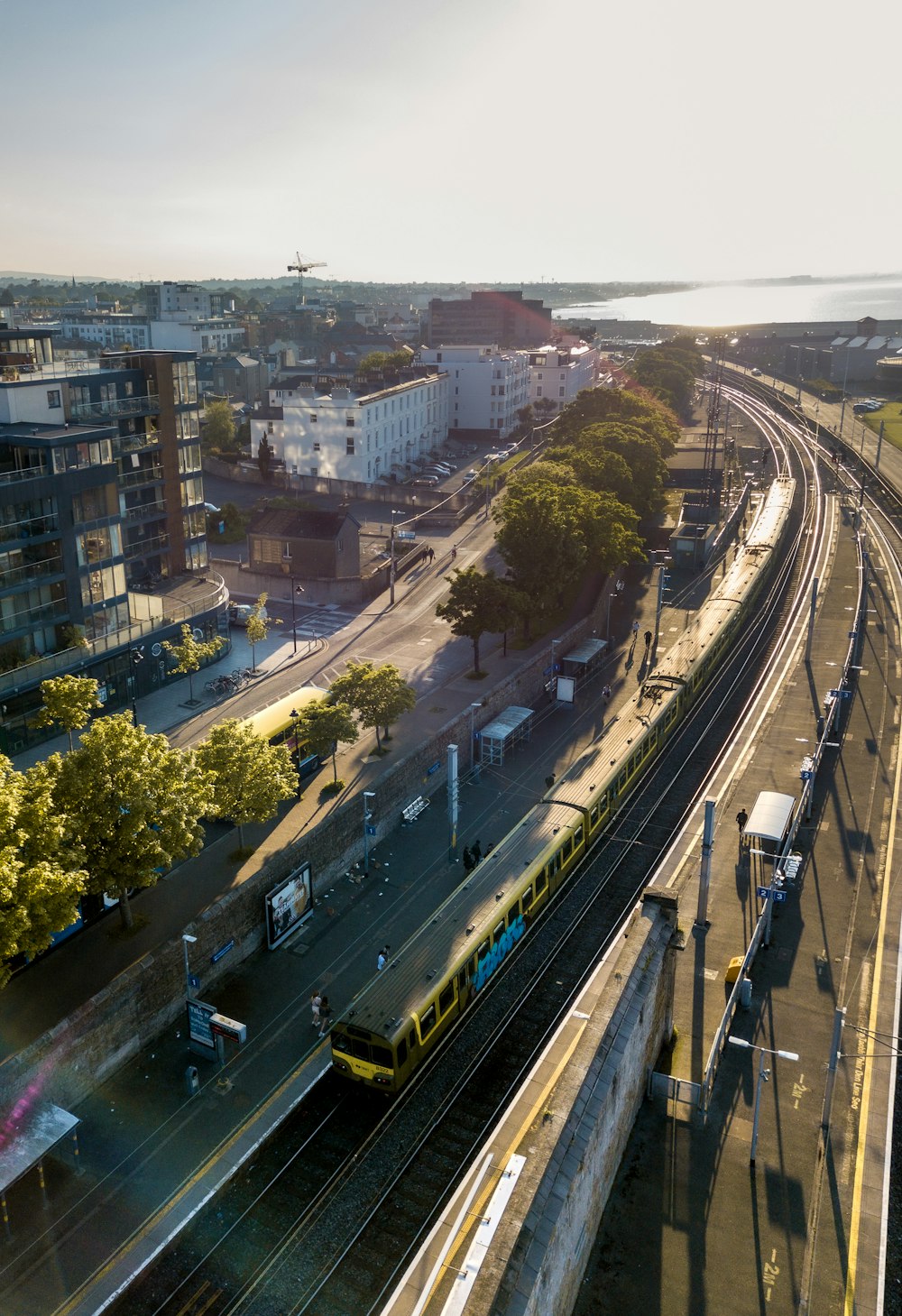 um trem viajando pelos trilhos do trem ao lado de uma cidade