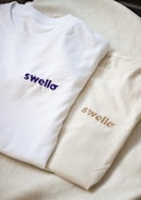 a couple of white shirts sitting on top of a bed