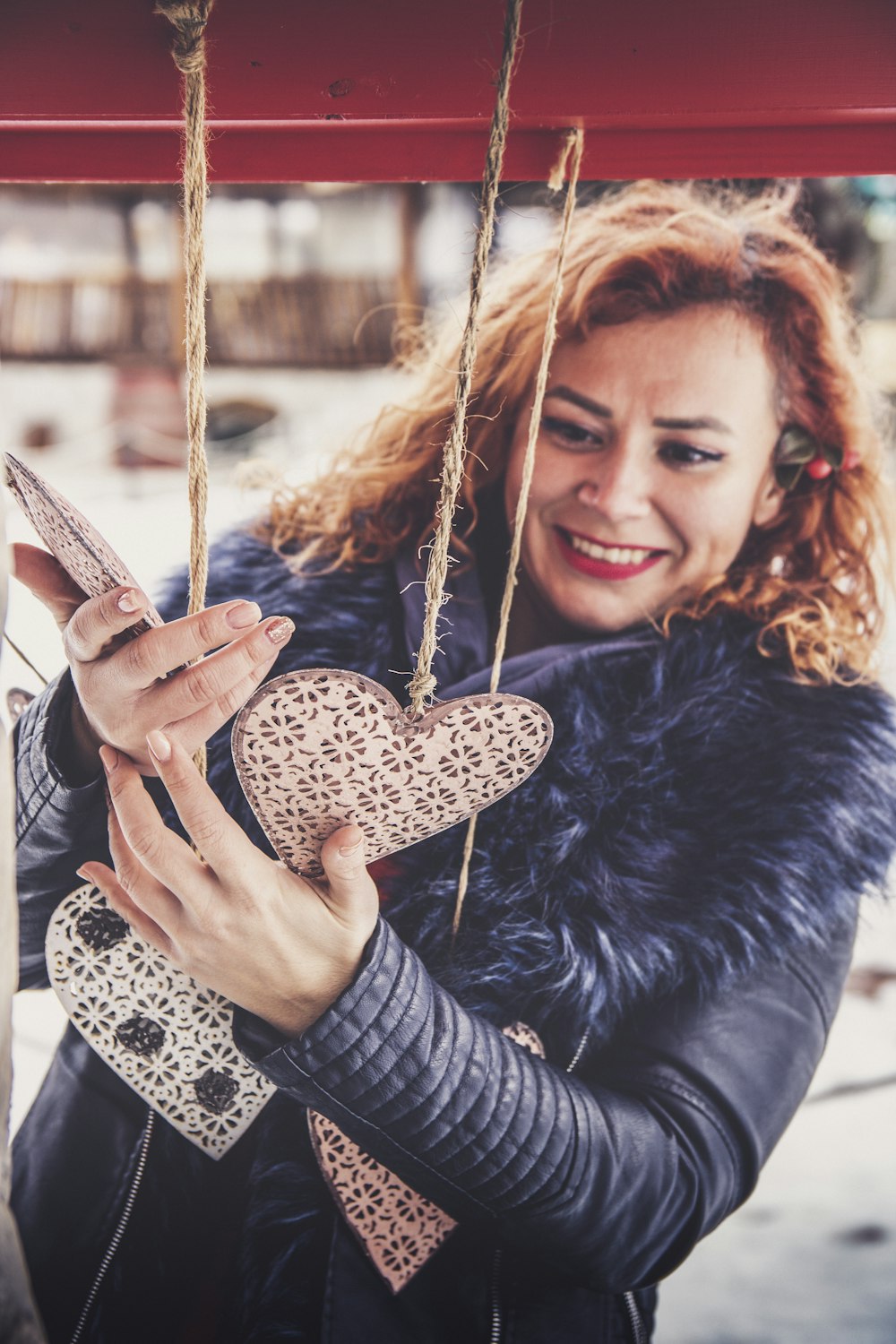 a woman holding a pair of gloves on a swing