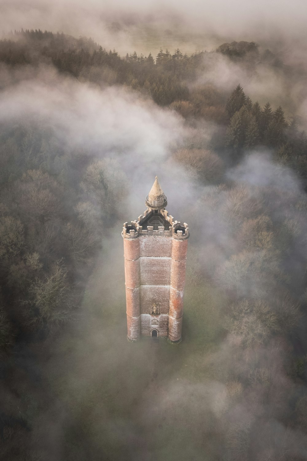 an aerial view of a tower in the middle of a forest