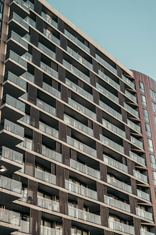 A modern high-rise residential building with glass balconies.