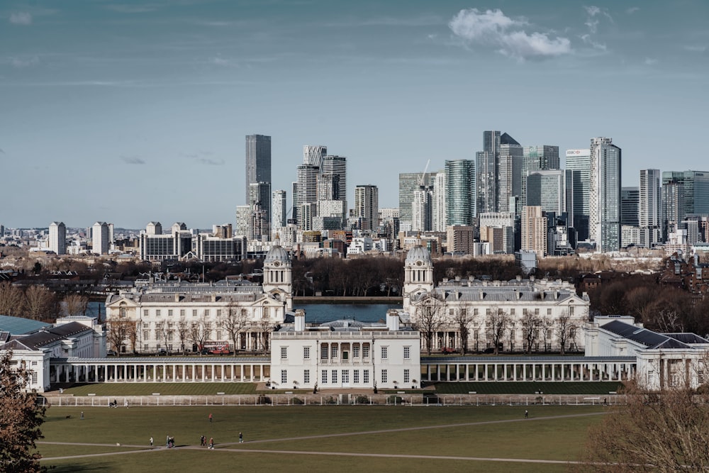 a large white building with a city in the background