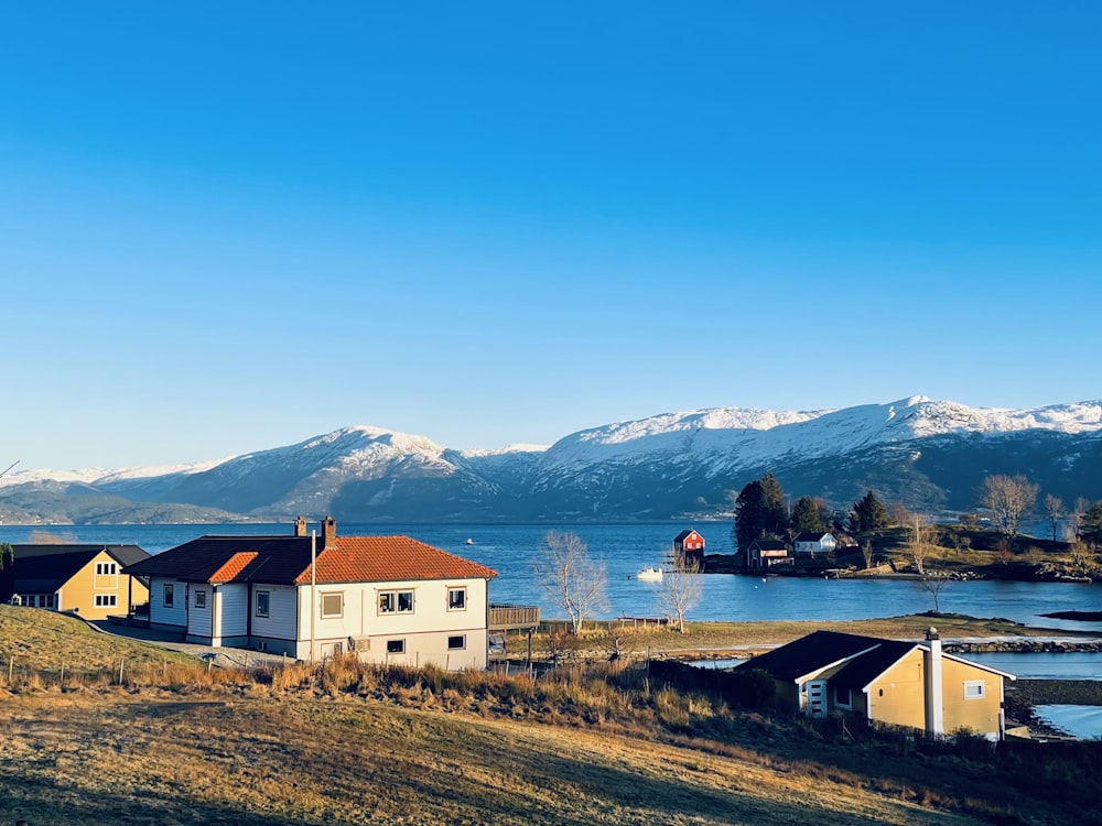 Una casa bianca seduta sulla cima di una collina vicino a un lago