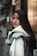 A young woman wearing a cozy oversized hoodie with streetwear style in an urban setting.