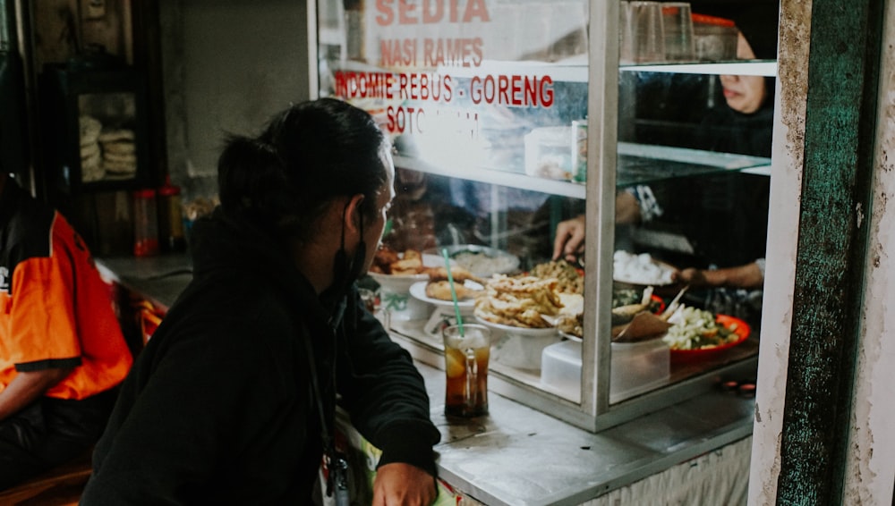 a woman standing in front of a counter filled with food