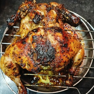 a cooked chicken sitting on top of a metal rack