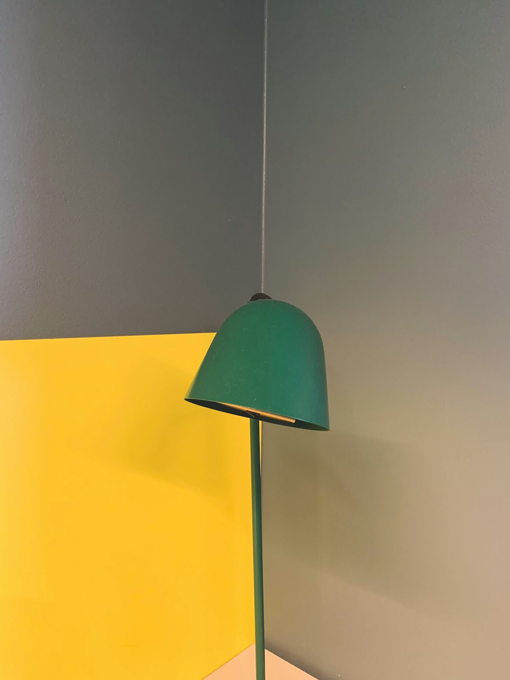 a green lamp sitting on top of a wooden table